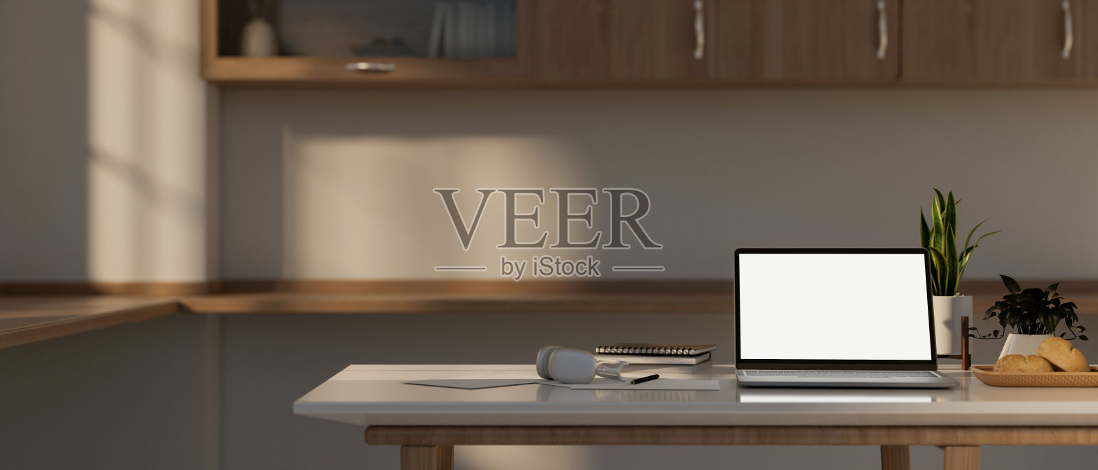 一台笔记本电脑的模型和厨房桌子上的装饰，在一个现代的，极简主义的厨房。照片摄影图片