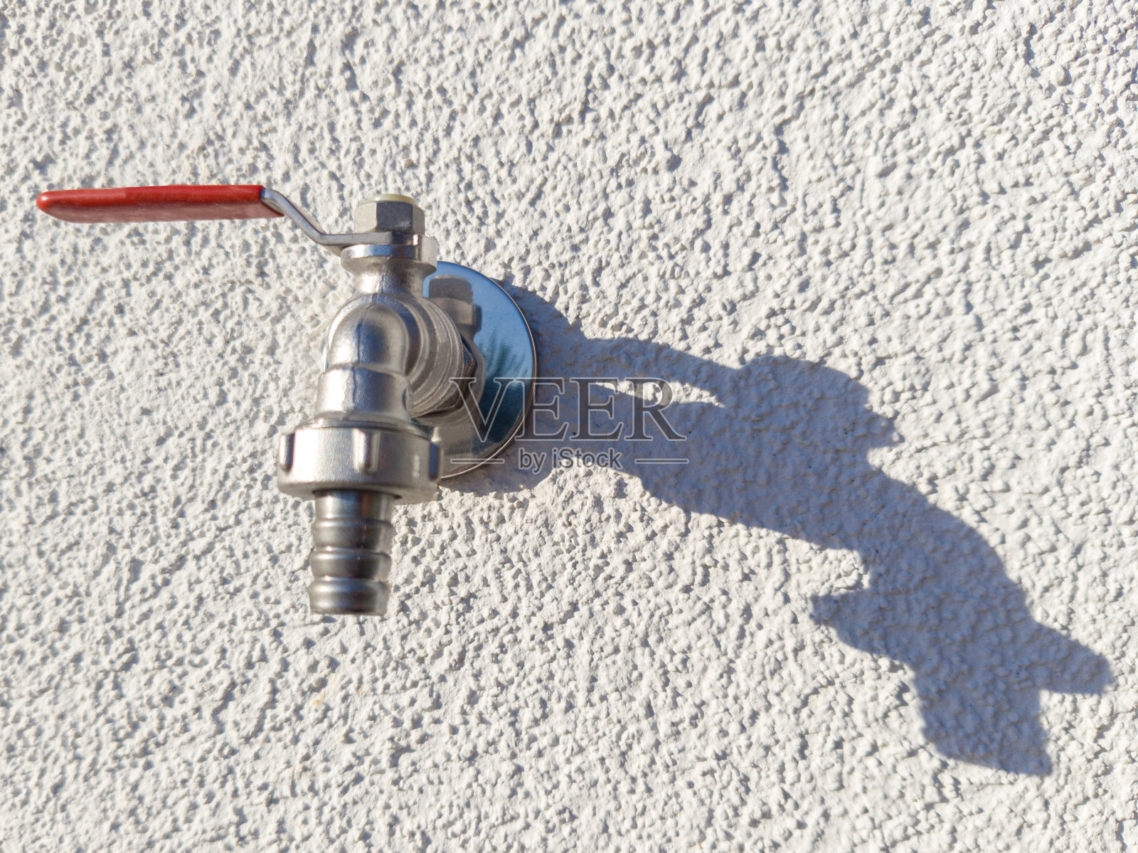 户外水龙头，红色手柄投射阴影照片摄影图片