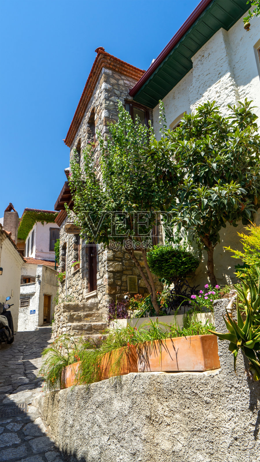 土耳其马尔马里斯老城狭窄的街道上装饰着房屋和门，还有绿色的植物。城市的历史部分。垂直的图像。在美丽的地方旅行、旅行和冒险照片摄影图片