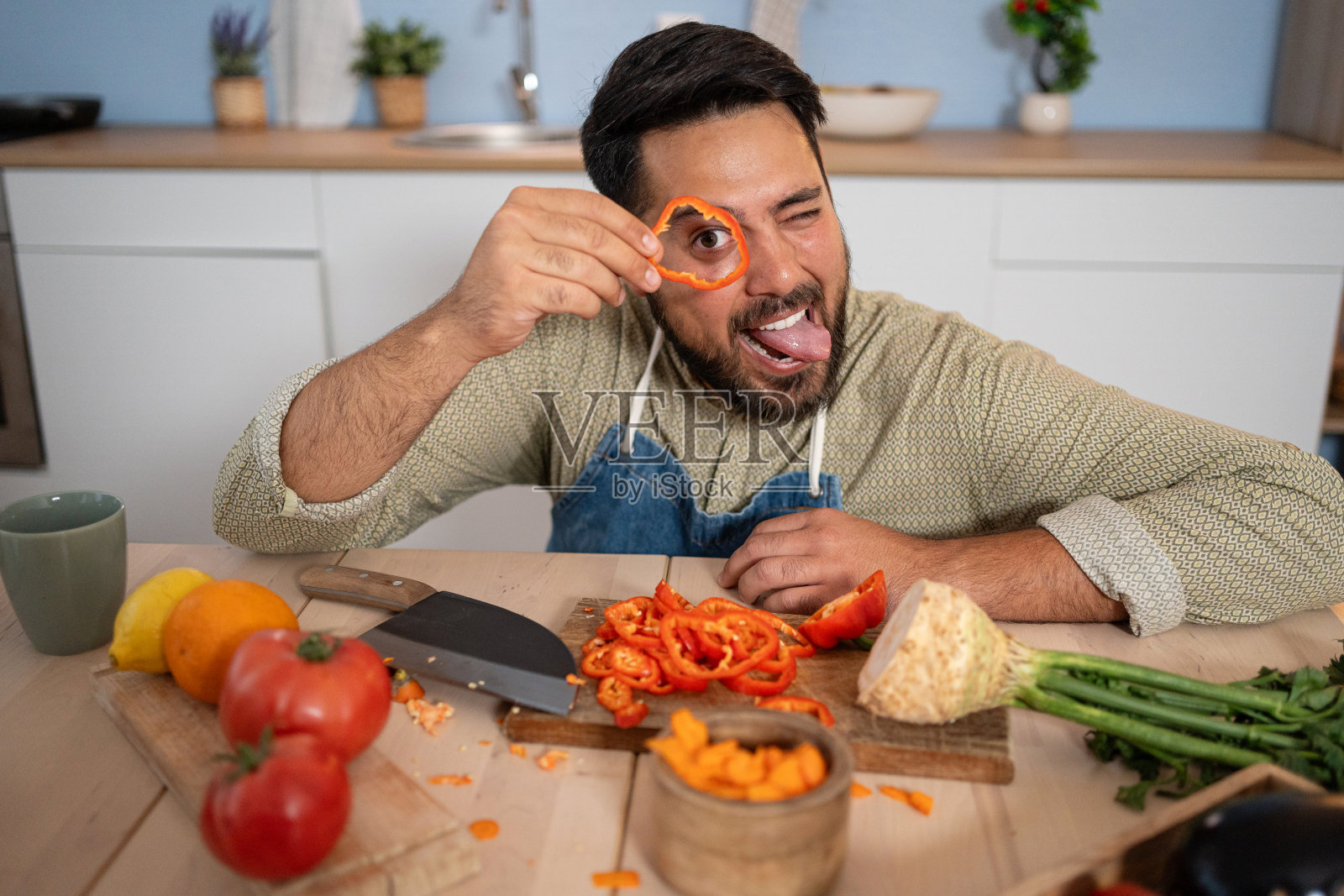 这位年轻的厨师在准备过程中很享受幽默的时刻。照片摄影图片