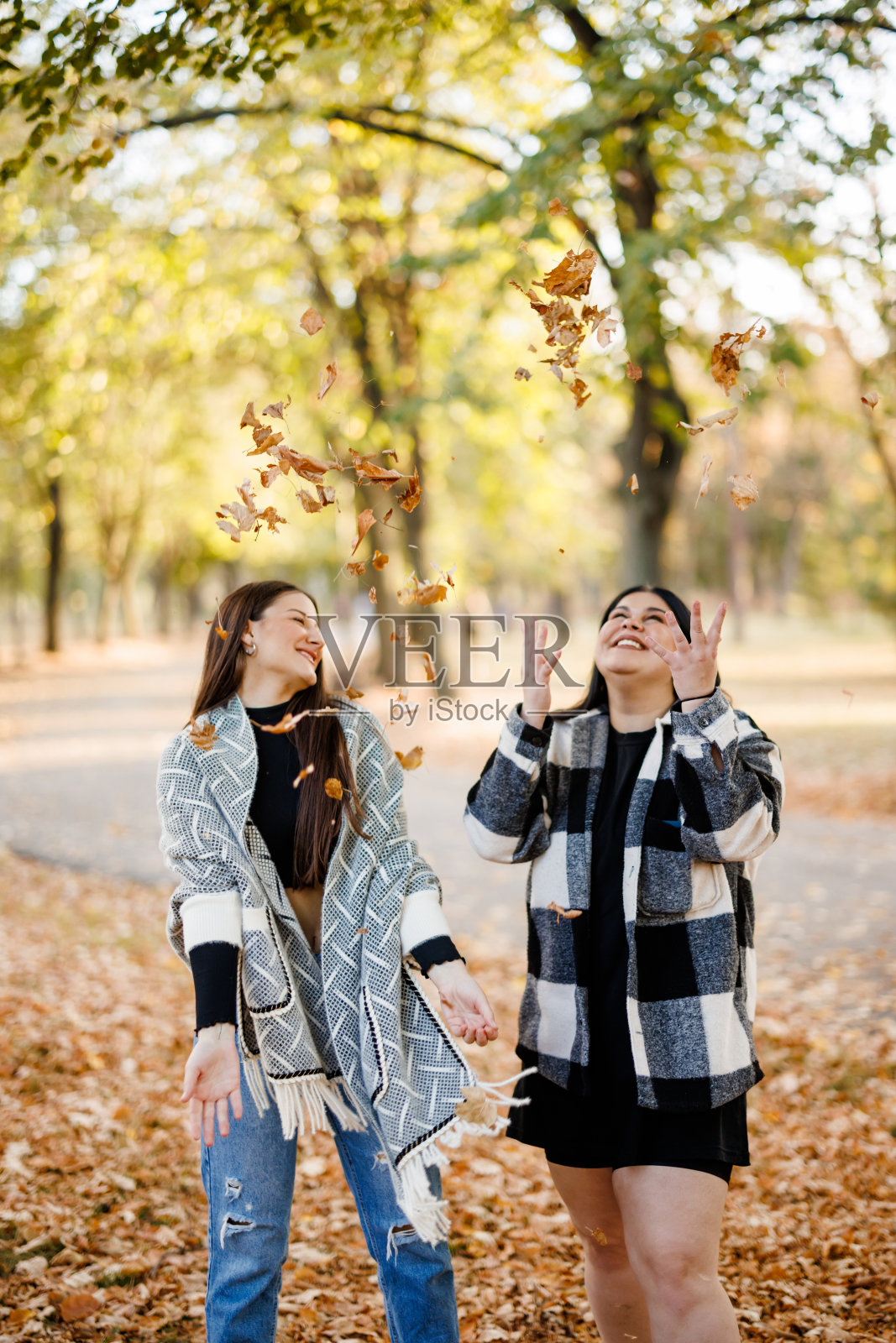 女性朋友在秋天的公园里玩耍照片摄影图片
