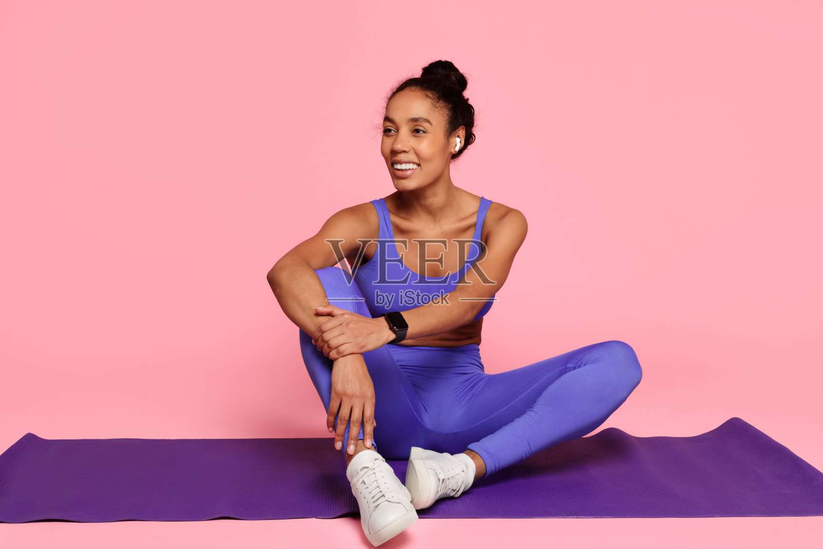 穿蓝衣服的健美女子坐在瑜伽垫上照片摄影图片