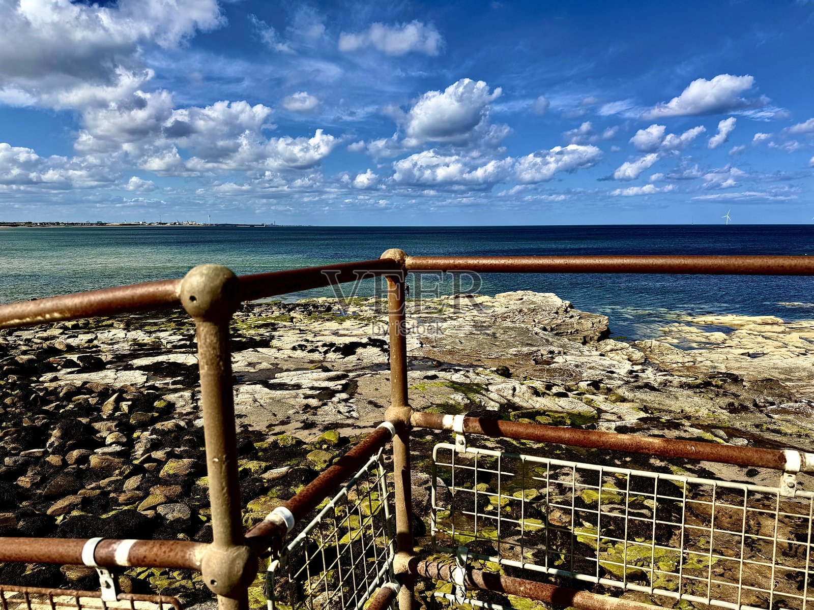 诺森伯兰郡崎岖海岸线上生锈的金属安全栅栏照片摄影图片