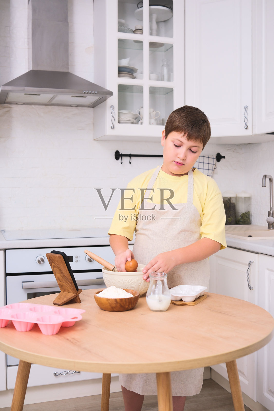 一个孩子在明亮、充满快乐活力的现代厨房里烘烤美味的食物照片摄影图片