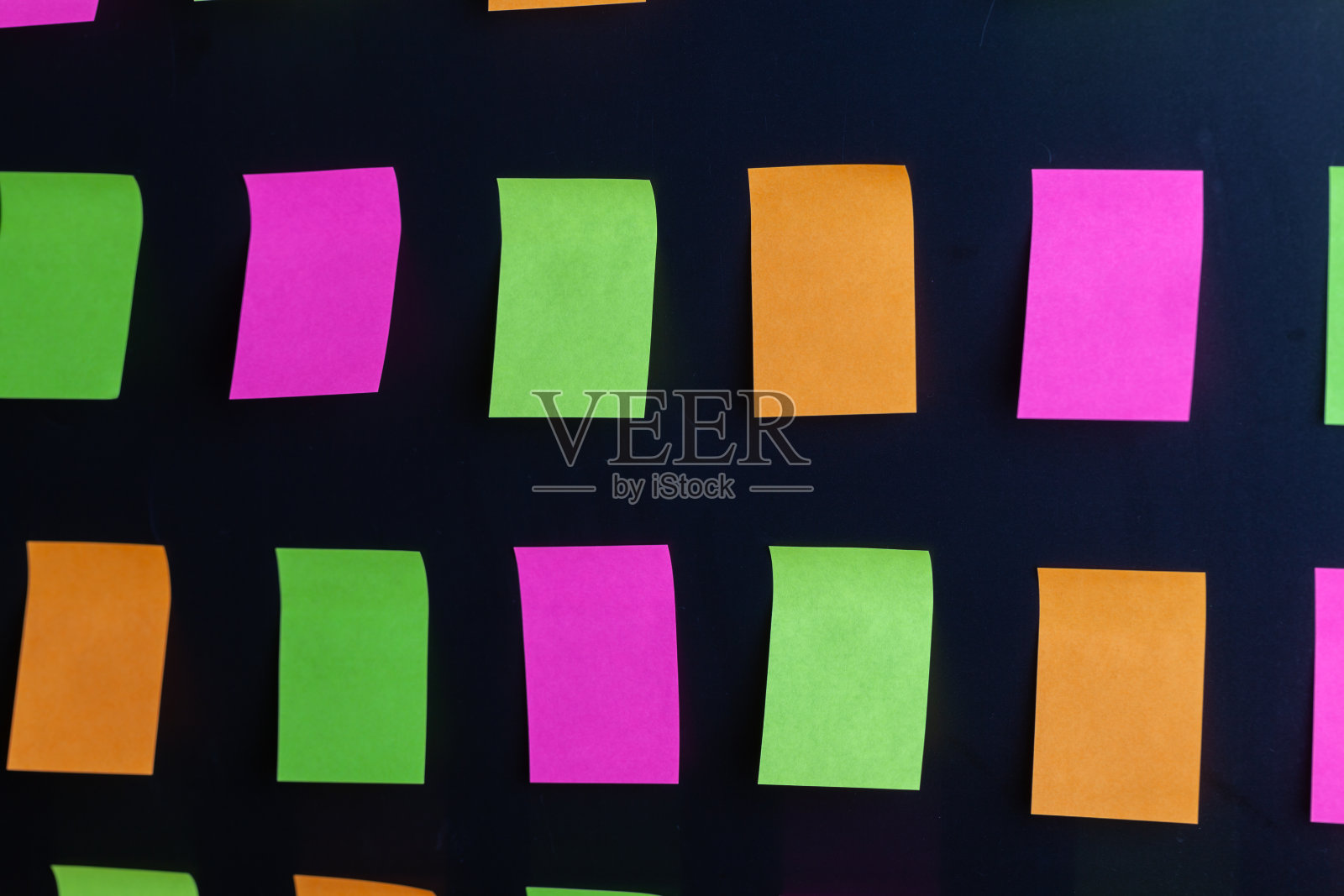 彩色便签贴在黑色的背景上照片摄影图片