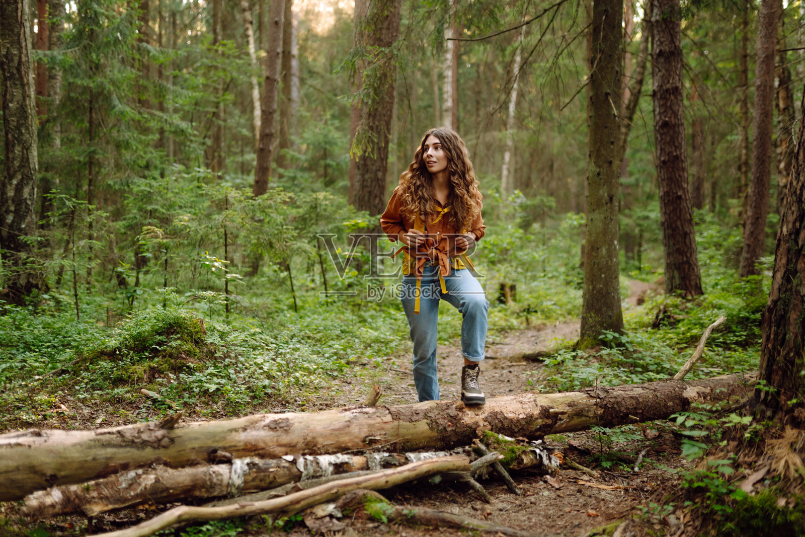 年轻女子欣赏森林景色。照片摄影图片