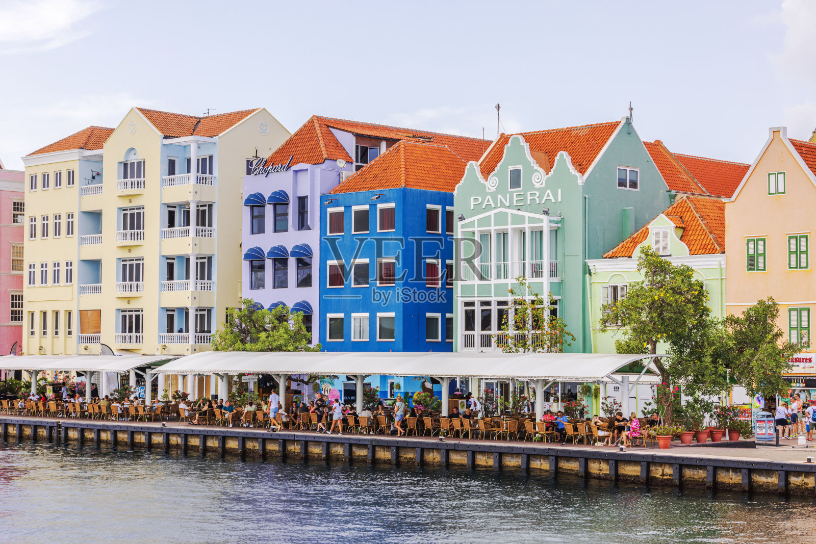 Willemstad色彩缤纷的海滨建筑，水边的户外餐厅，在阳光明媚的日子里，充满生机和活力。照片摄影图片