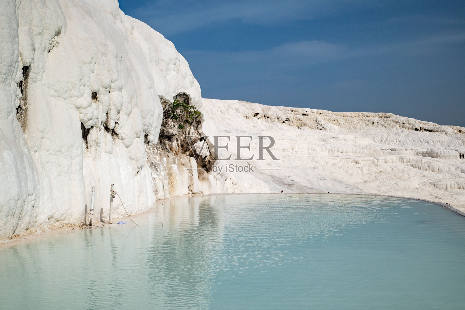 阳光明媚的一天，在土耳其西部的Pamukkale镇，石灰华露台和热水池照片摄影图片