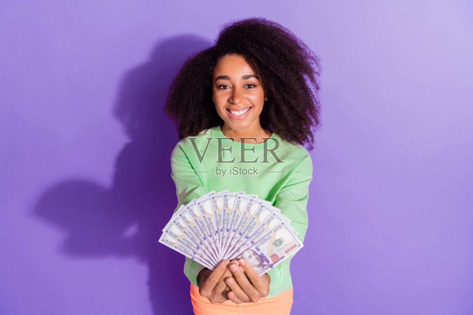 富有的年轻美国女孩的肖像与有趣的雪佛兰卷发显示大笔奖金彩票奖金孤立的紫色背景照片摄影图片