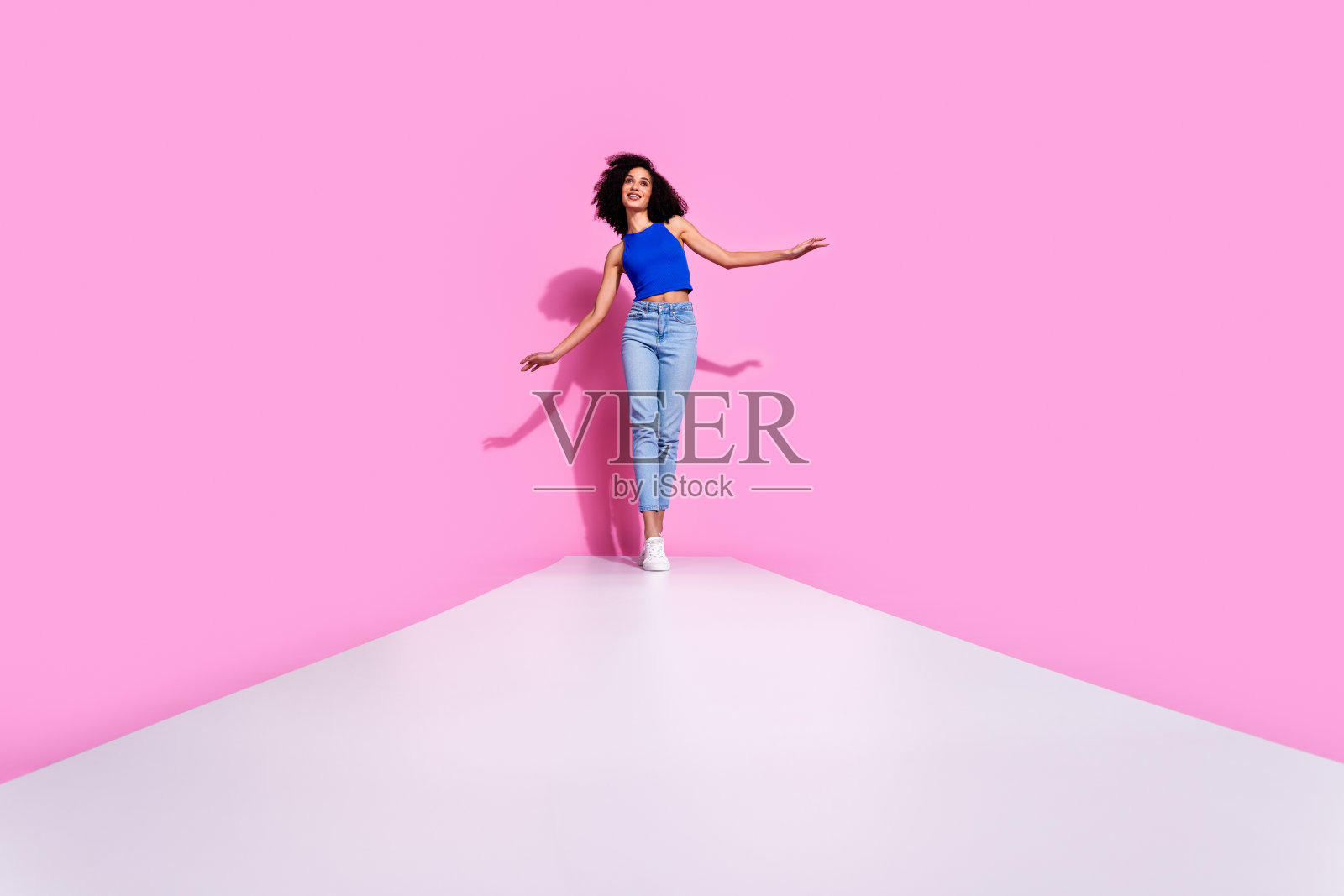 照片上的女孩走在白色的道路孤立的粉红色背景照片摄影图片