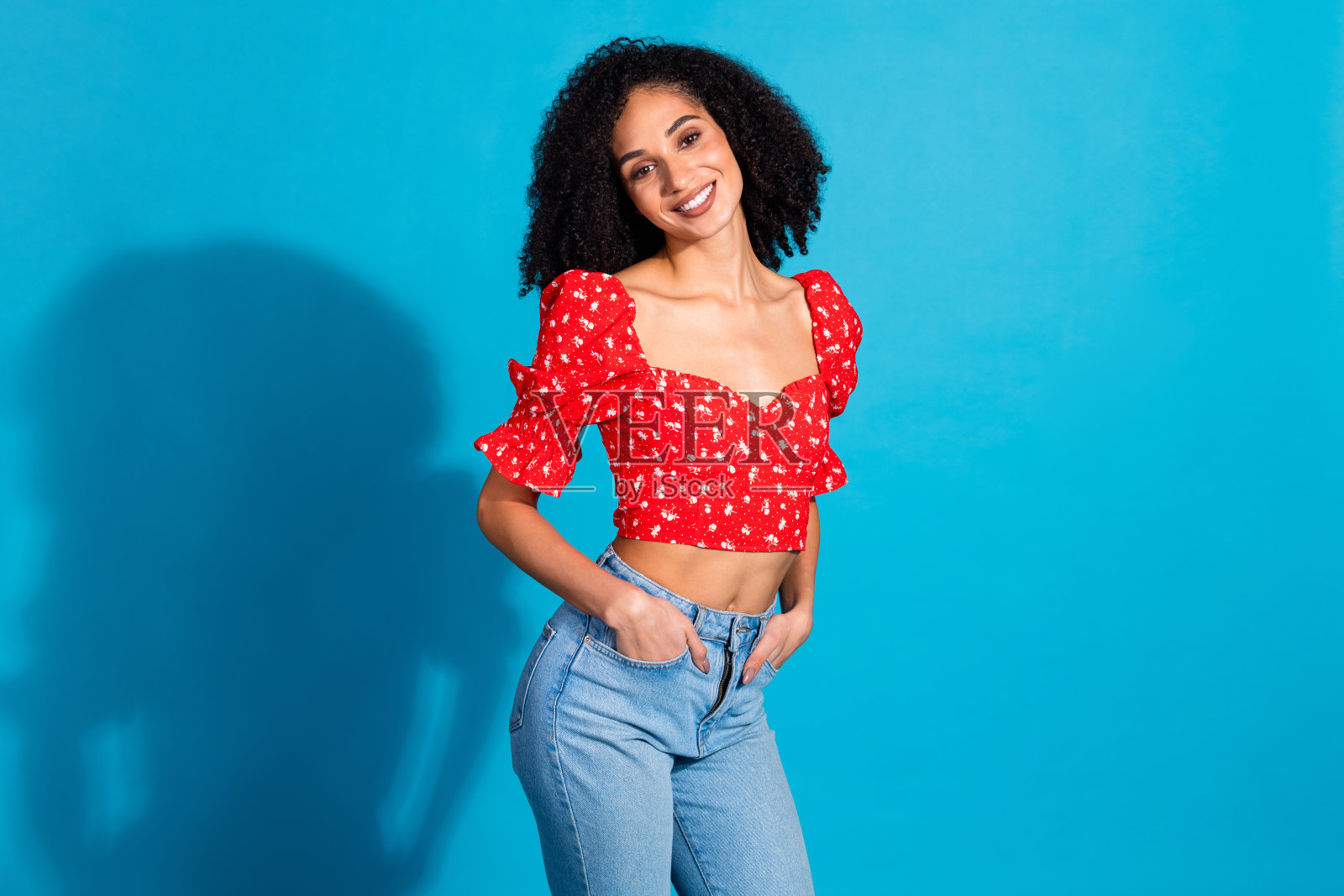 照片漂亮的年轻女子摆姿势穿着上衣孤立的蓝色背景照片摄影图片