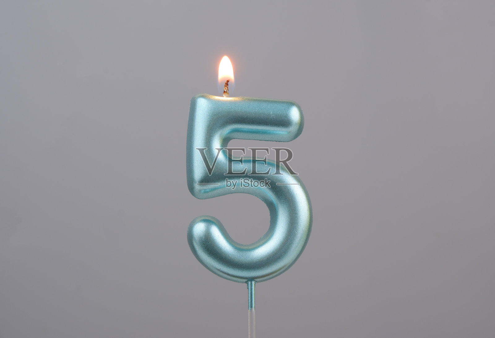 灰色背景上的蓝色生日蜡烛，五号照片摄影图片