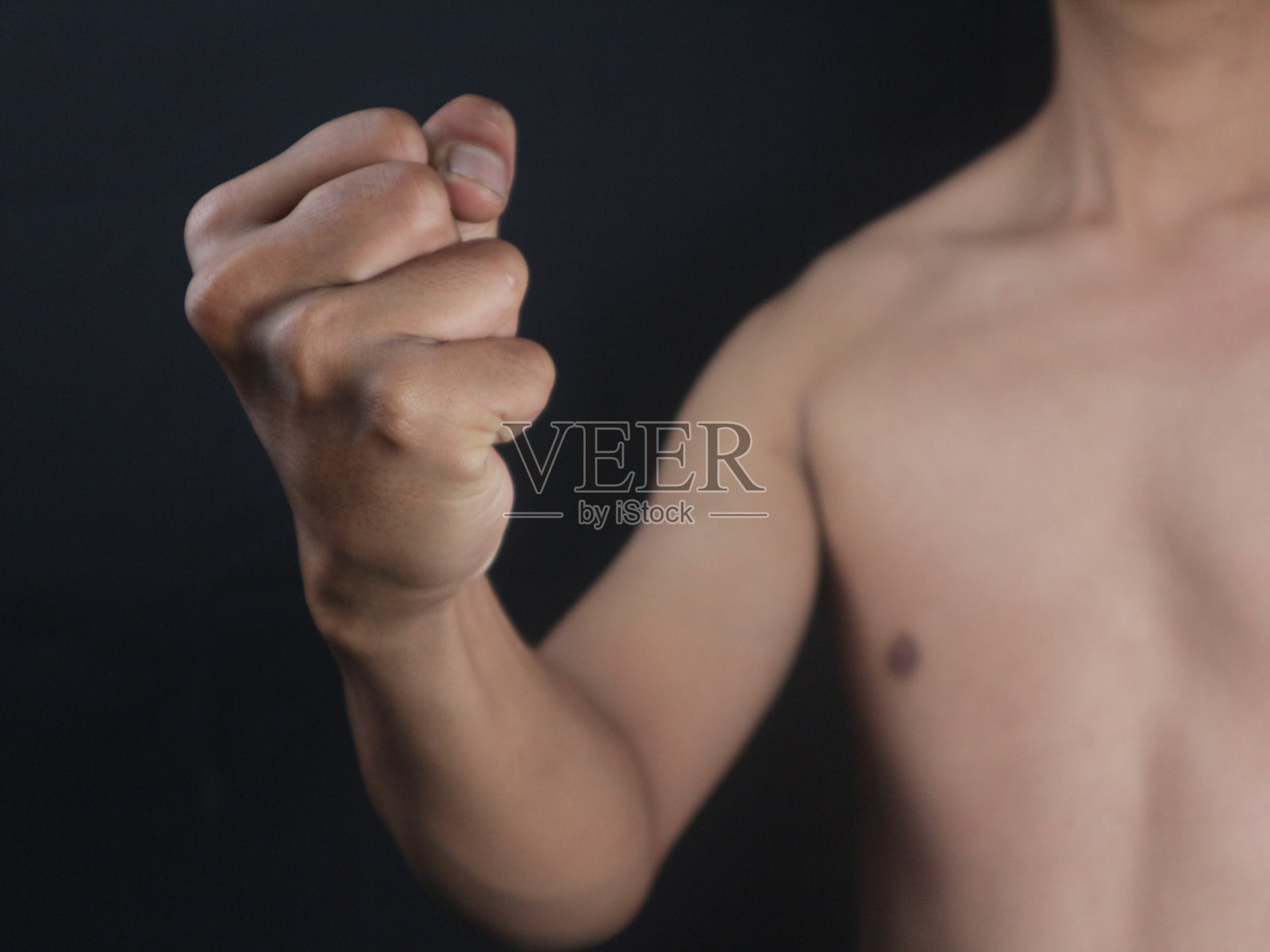 一个男人的拳头在黑色的背景上猛击照片摄影图片