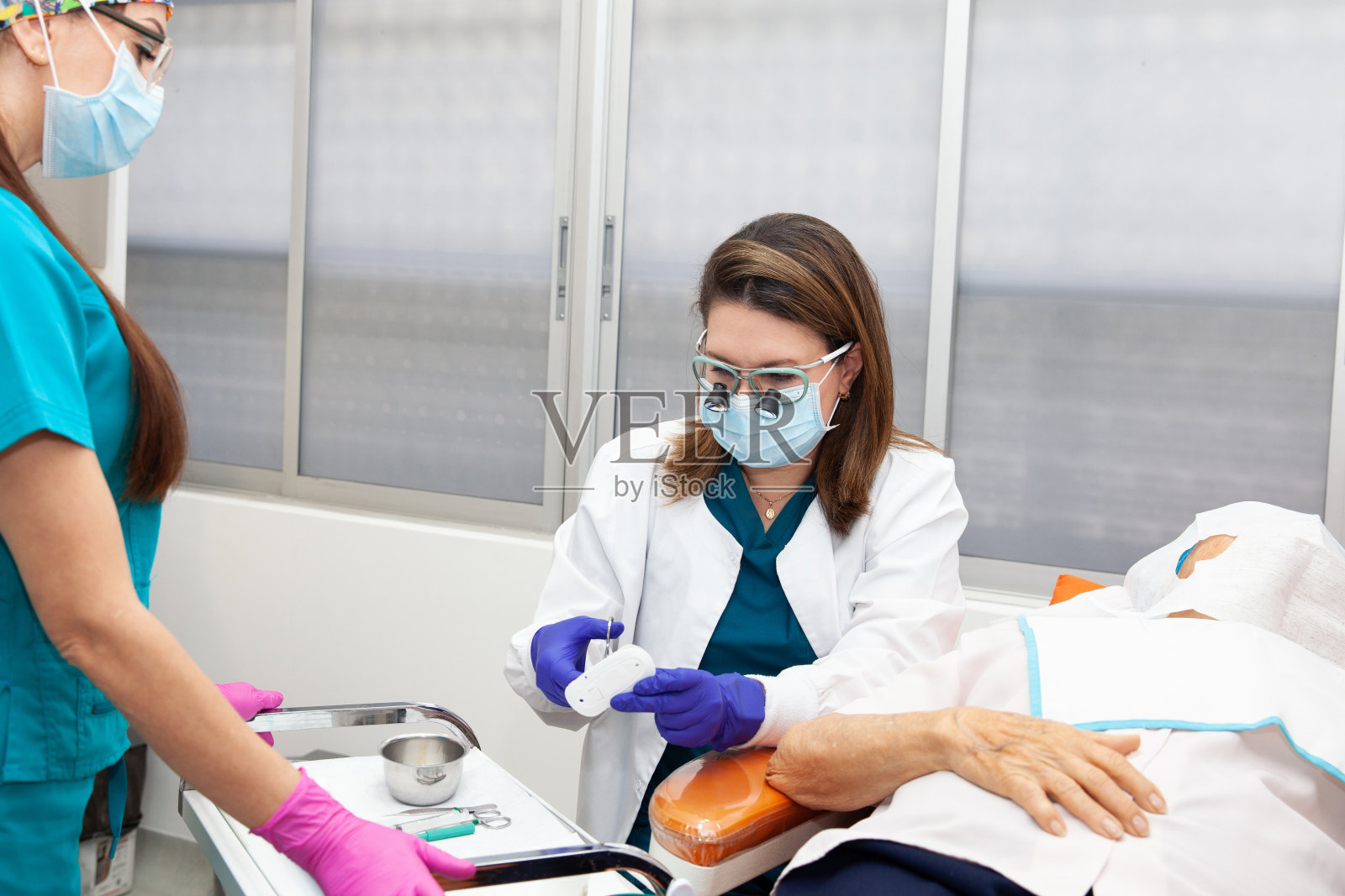 皮肤科医生正在对一位老年成人患者的面部进行皮肤活检照片摄影图片