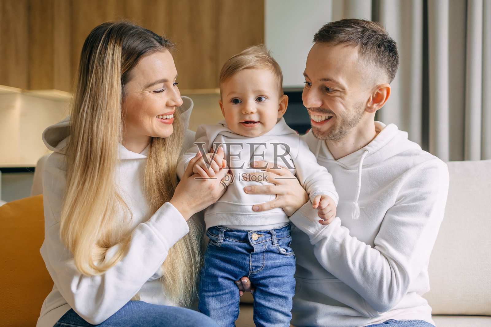 宝宝坐在沙发上的幸福家庭照片摄影图片