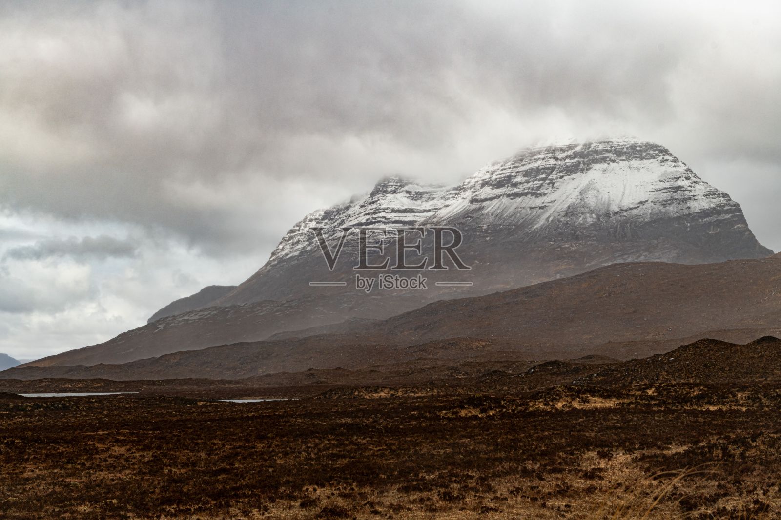 风景优美的苏格兰高地消失在雾蒙蒙的山脉中，两边都是茂密的树叶照片摄影图片