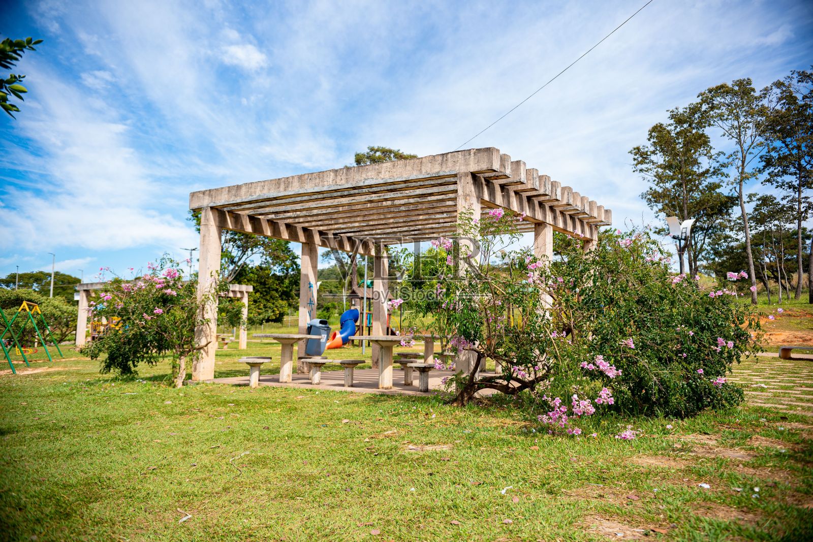 蓝天下的公园区域有混凝土凉棚和野餐桌照片摄影图片
