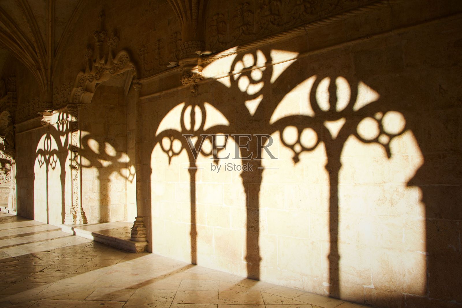 错综复杂的哥特式拱门投在石墙上的阴影照片摄影图片