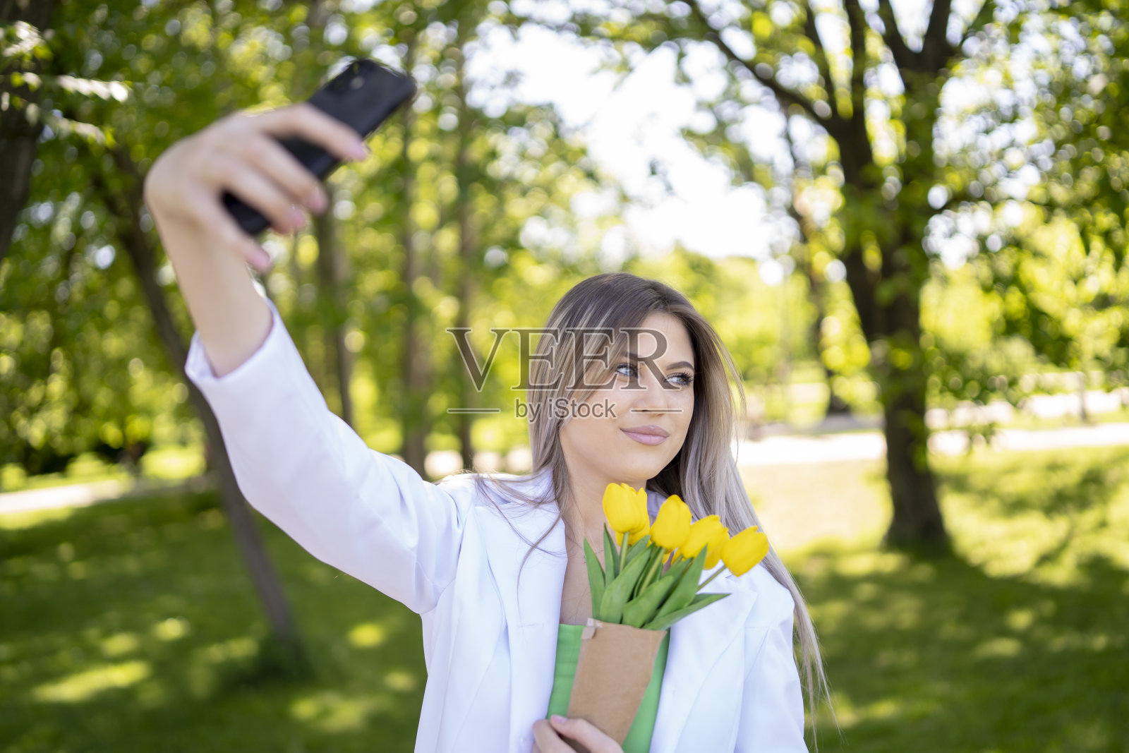 年轻漂亮的女人拿着一束郁金香花照片摄影图片