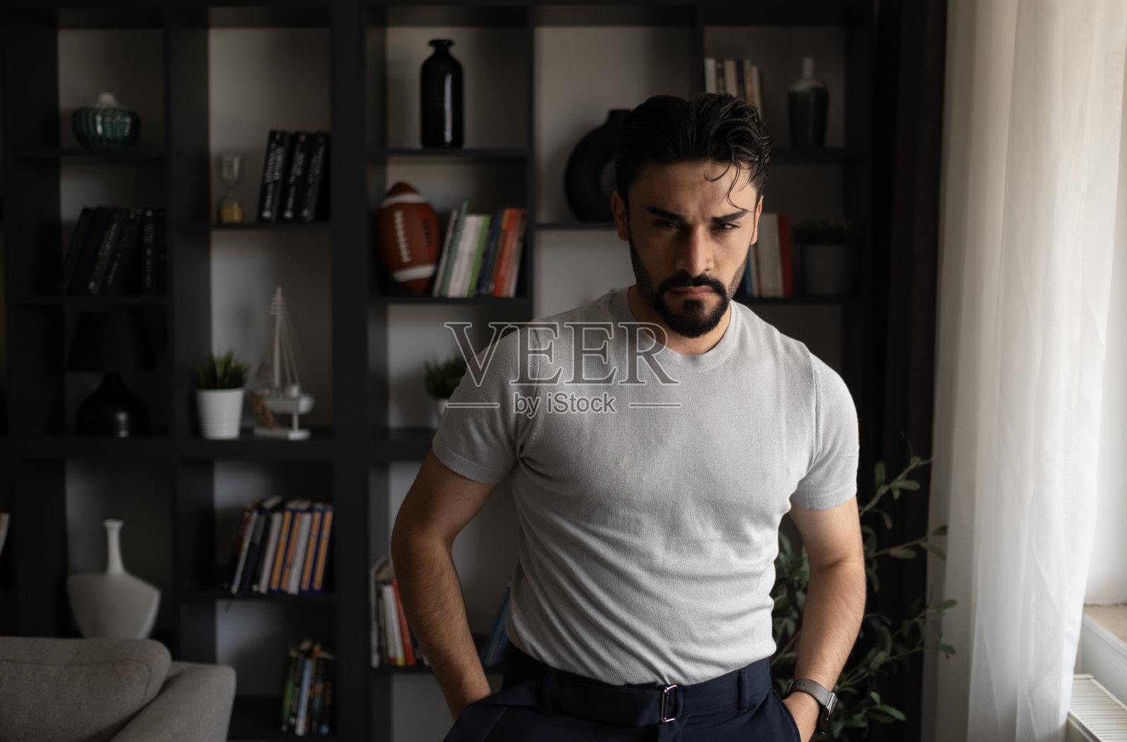 商业生活方式。随意的黑发年轻的职业英俊的商人站在他的办公室靠窗照片摄影图片