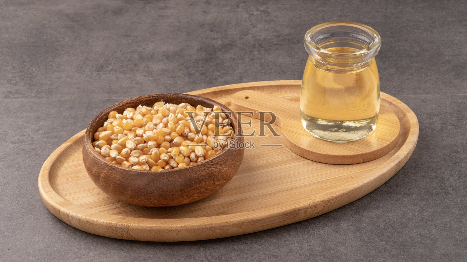 装有玉米和玻璃瓶的木托盘。含有玉米粉和油。照片摄影图片