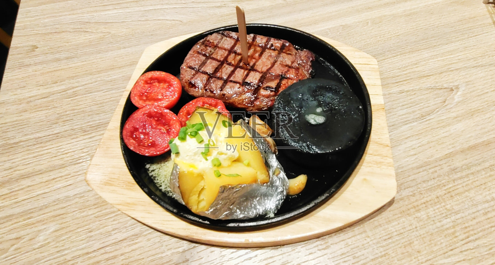 欧洲食物:肋眼牛排配烤西红柿、土豆和牛排酱照片摄影图片