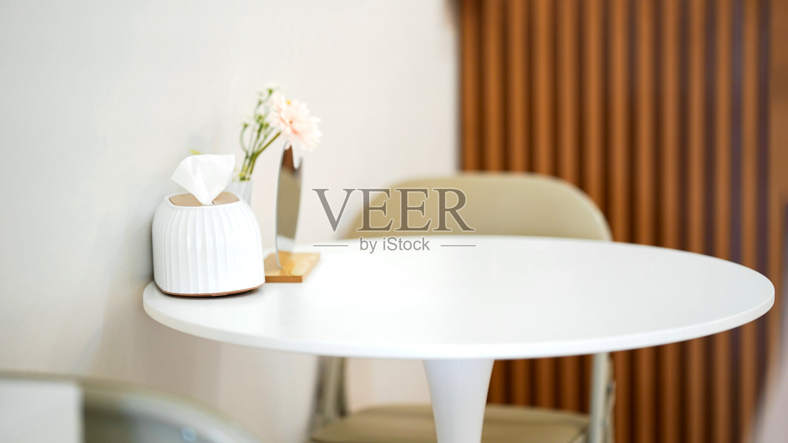 优雅的极简主义的桌子，一个小花瓶和纸巾架，创造一个舒适和干净的室内空间，放松或工作。照片摄影图片
