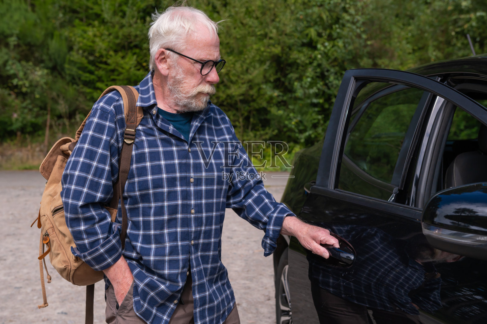 一位退休老人正在打开一扇车门照片摄影图片