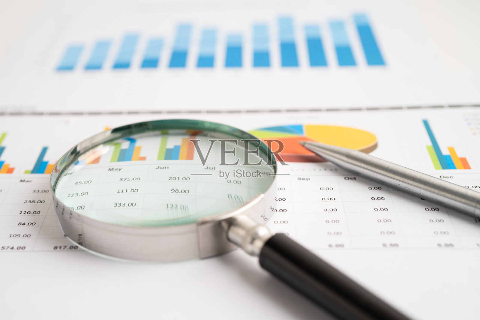 放大镜上的图形。金融、商业和贸易。照片摄影图片