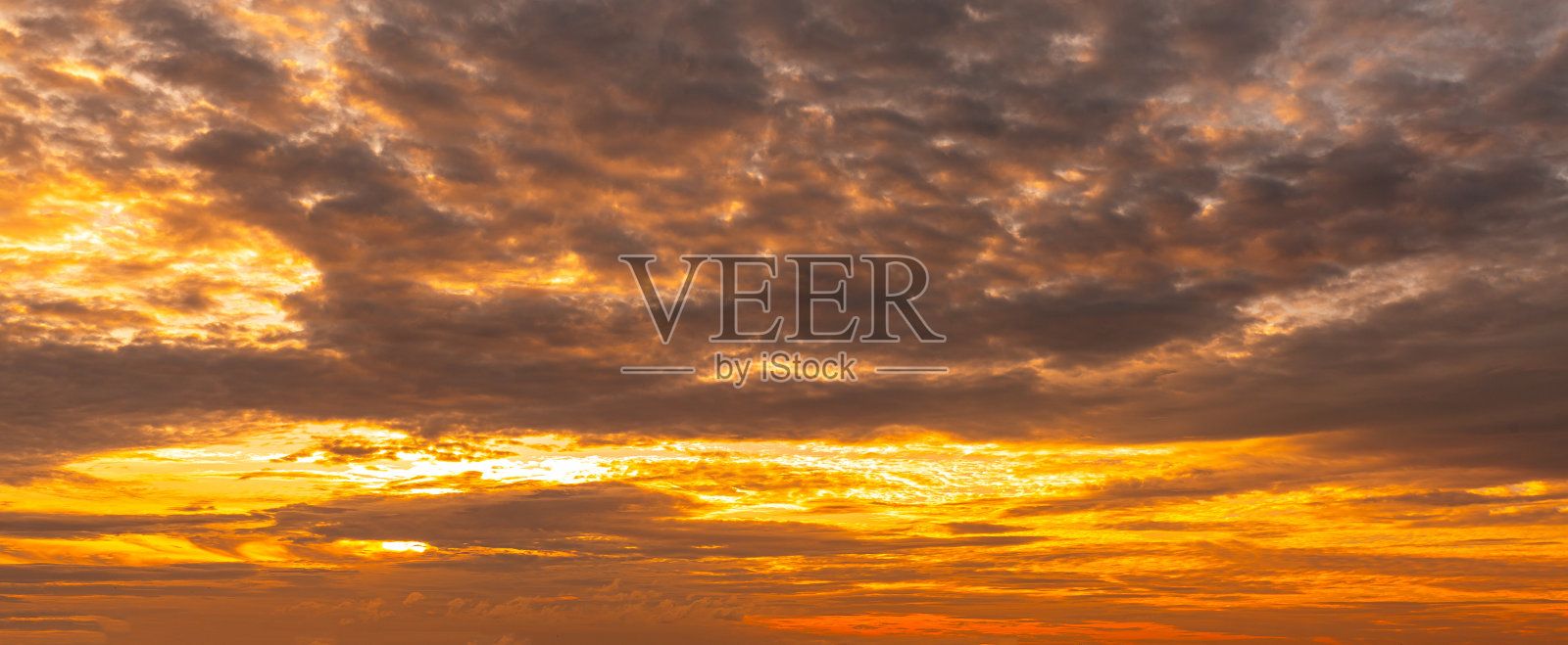 五颜六色的云和天空。黄昏和日落。傍晚的云，橙色，黄色，粉红色和红色的阳光和惊人的风暴云在黄昏的天空。照片摄影图片