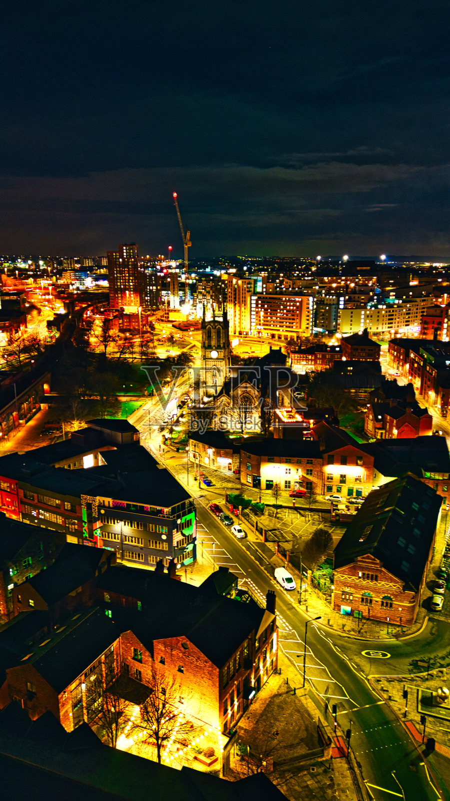 垂直夜景，充满活力的灯光和繁忙的街道，展示了英国利兹的城市建筑和繁华的夜生活。照片摄影图片