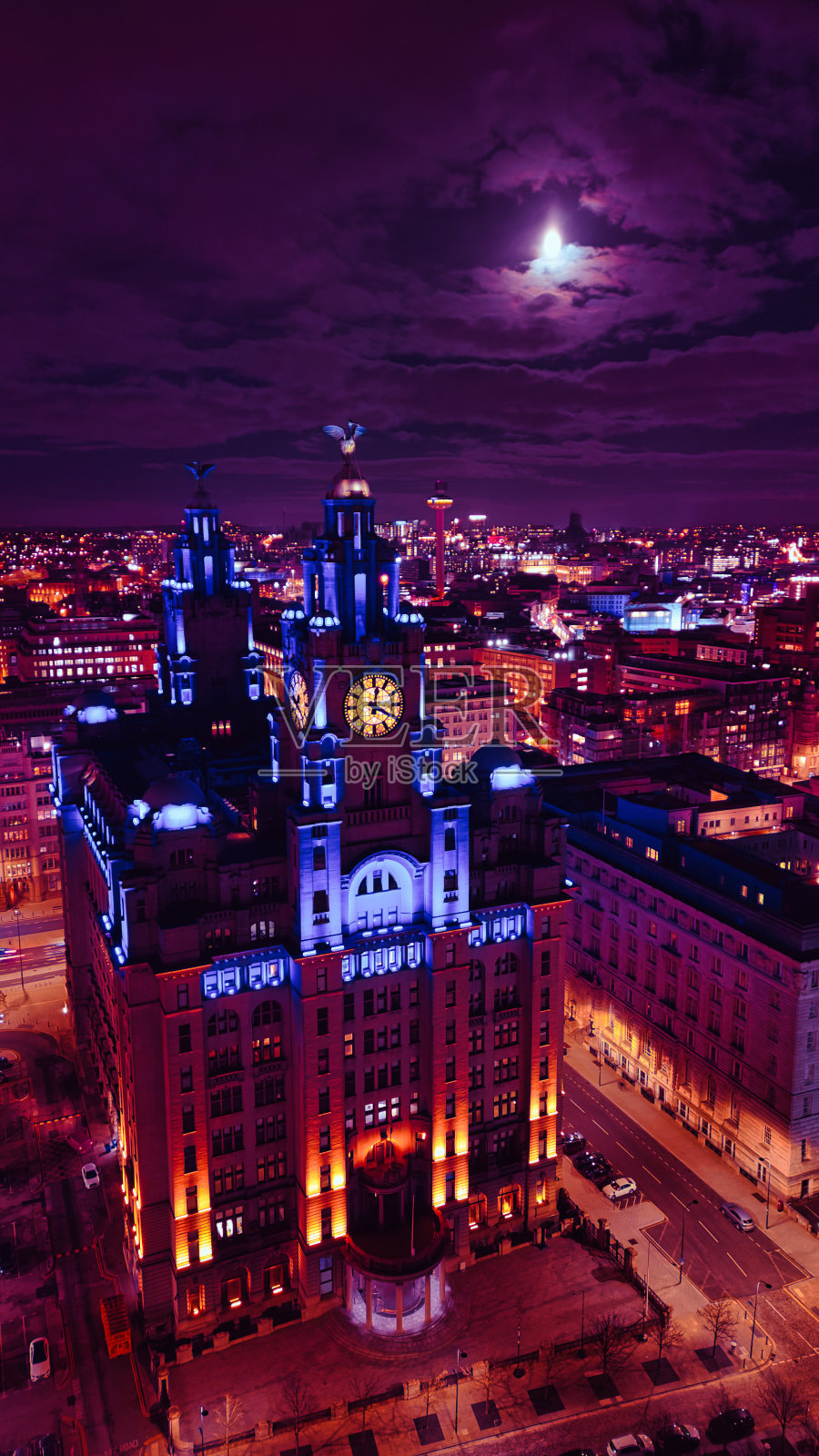 月光下的城市景观，夜晚照亮的历史建筑，在英国利物浦戏剧性的天空下展示城市建筑。照片摄影图片