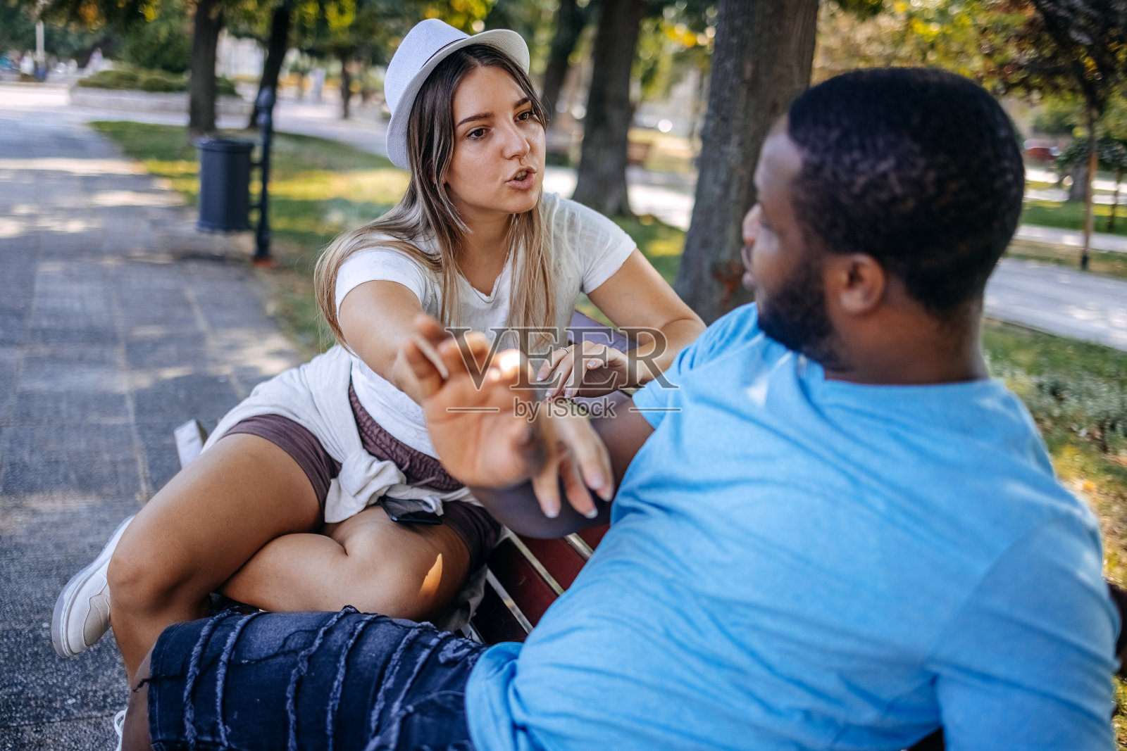 一对年轻的多种族情侣在公园分手，因为他们在试图伸手去拿男朋友的手机时关系出现了问题照片摄影图片