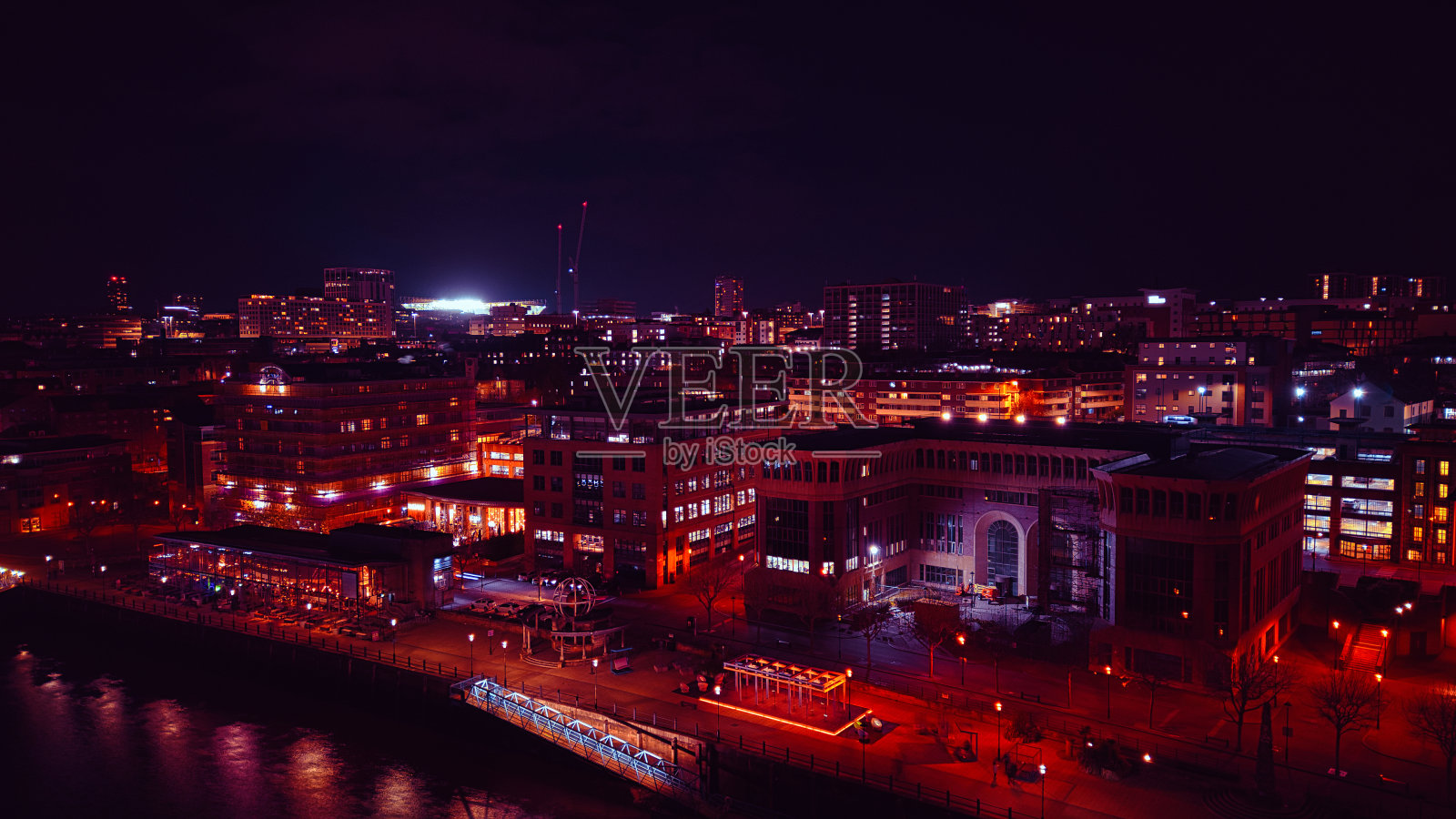 夜晚的城市景观，灯火通明的建筑和海滨，展示了泰恩河畔纽卡斯尔的城市夜生活和建筑照片摄影图片