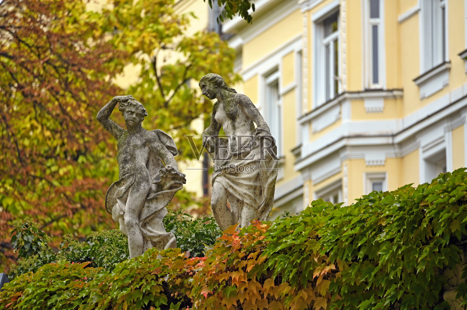 奥地利维也纳古老的石像和五彩缤纷的秋叶照片摄影图片