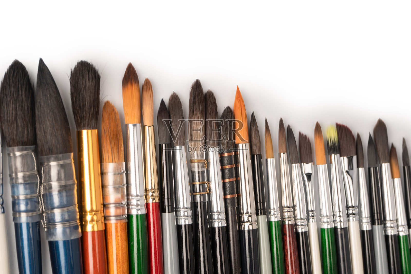 混合的油漆刷在一排孤立的白色背景。照片摄影图片