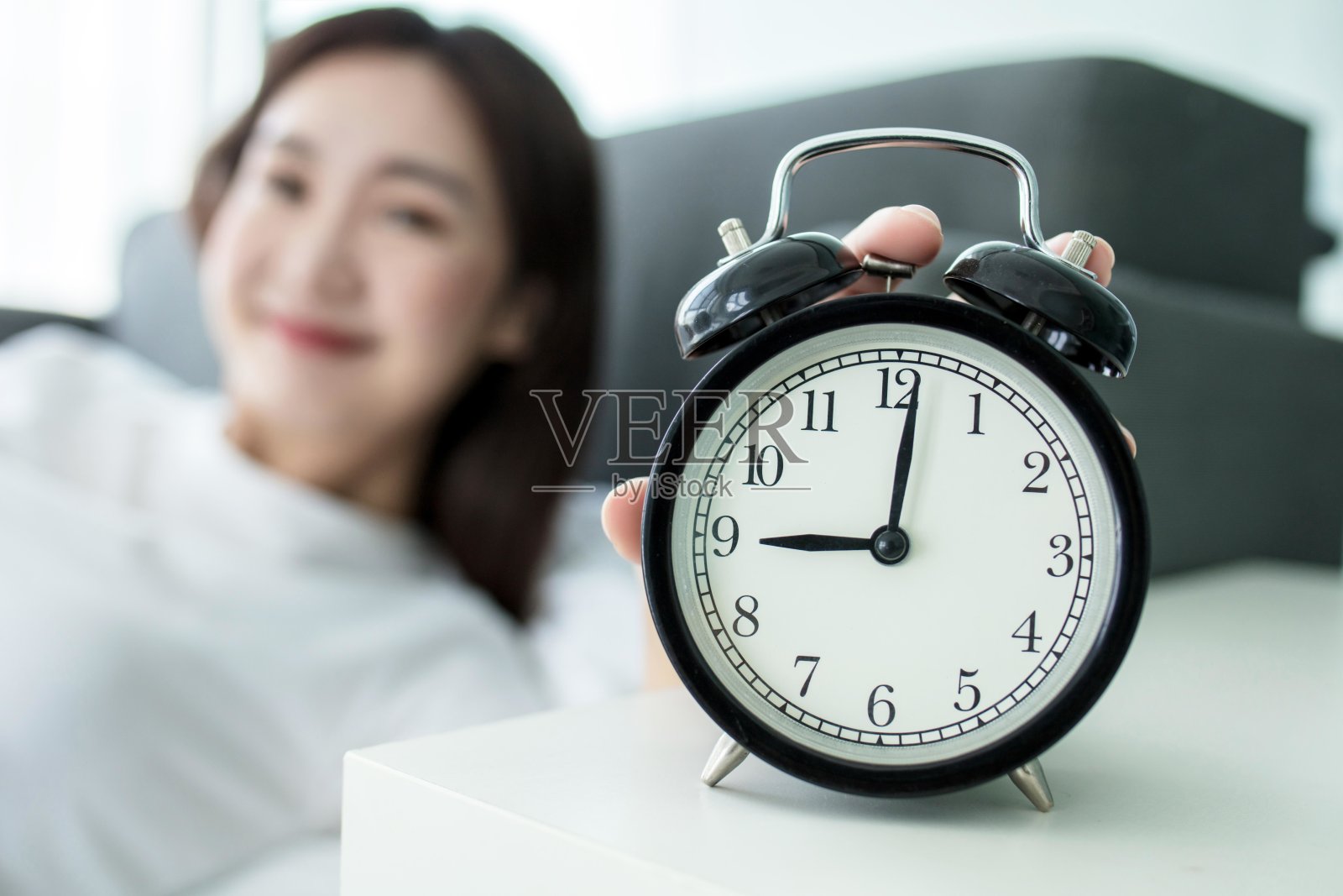 一个女人在早上关掉闹钟的照片照片摄影图片