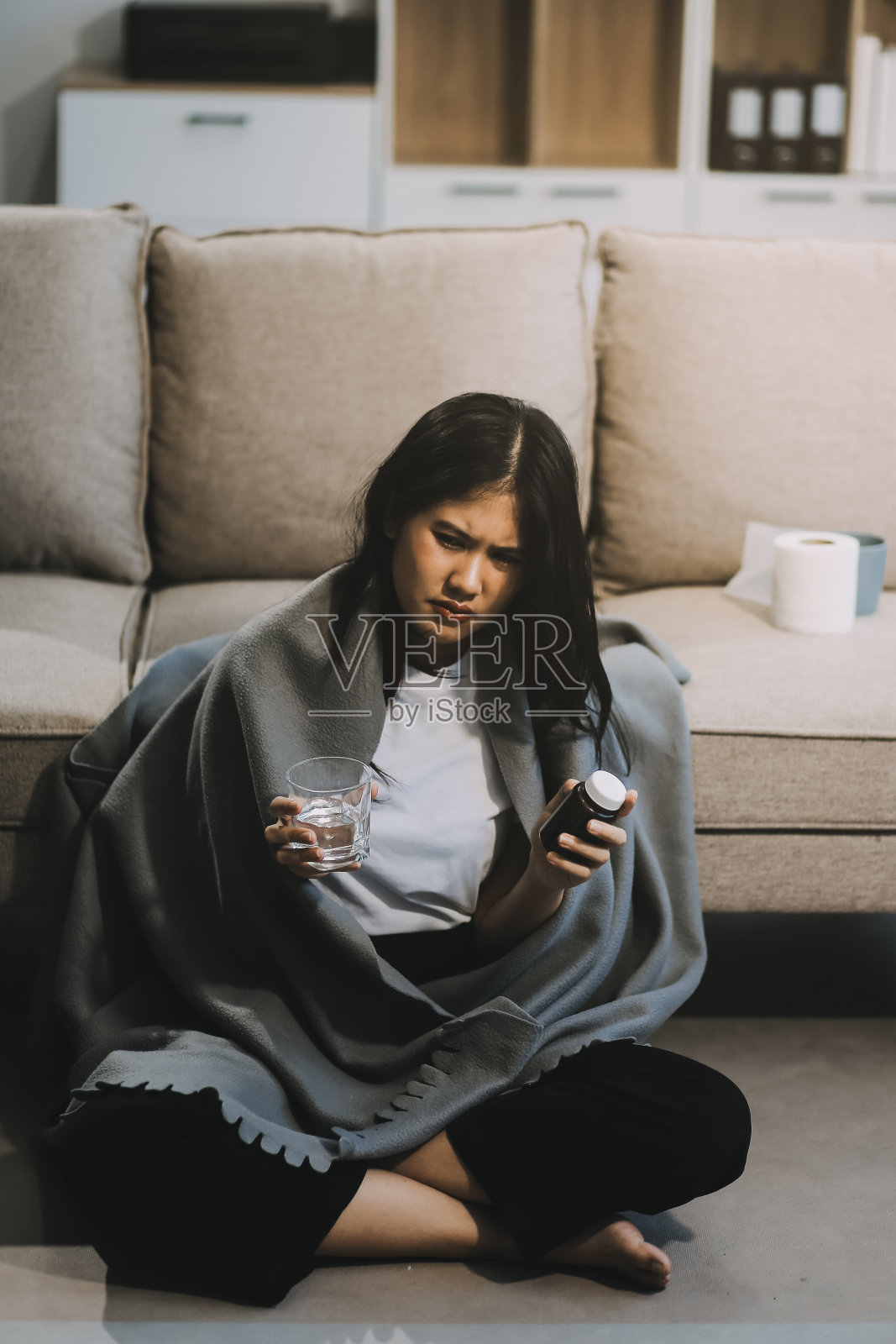 感冒药和生病的妇女喝热饮可以从流感、发烧和病毒中康复。桌子上有脏纸巾和纸巾。病人在冬天穿暖和的羊毛长袜。照片摄影图片