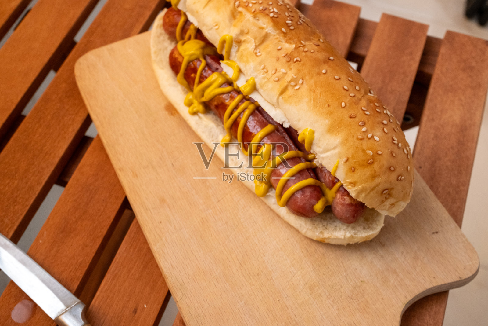 把番茄酱、蛋黄酱和芥末酱挤在法兰克福香肠上照片摄影图片