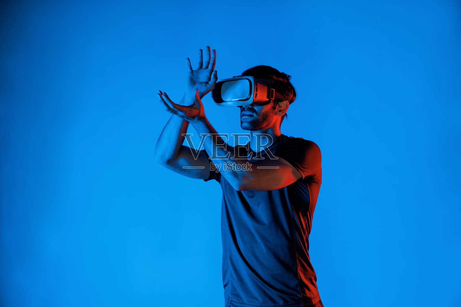 男子戴着带有霓虹灯的VR头显打篮球。偏差。照片摄影图片