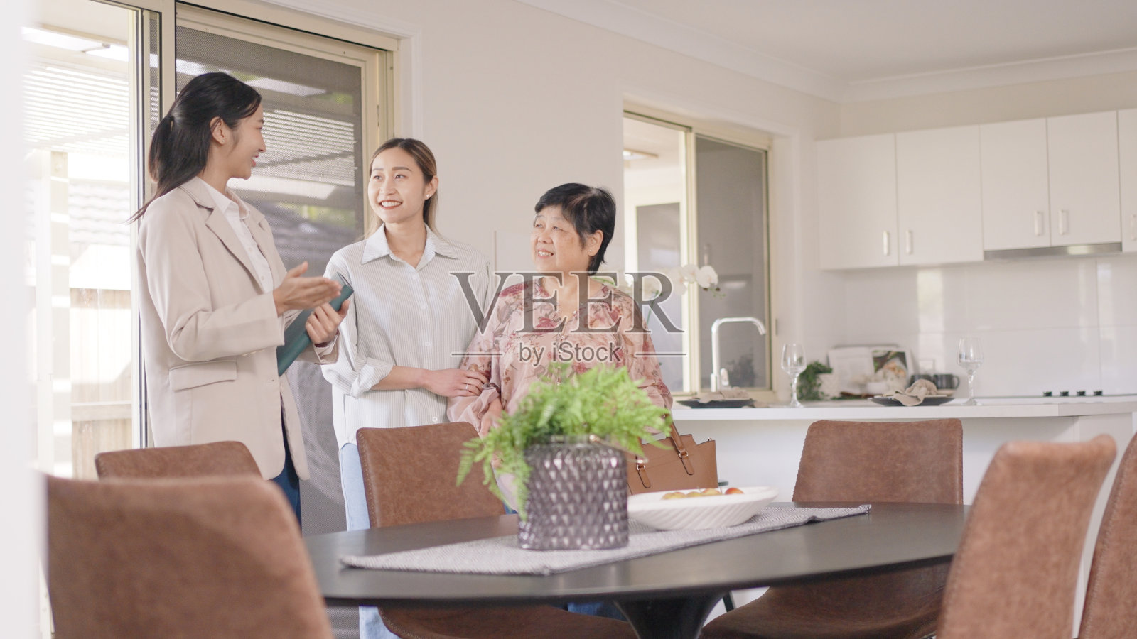 亚洲年轻的房地产经纪人向母女一家展示一处临时房产照片摄影图片
