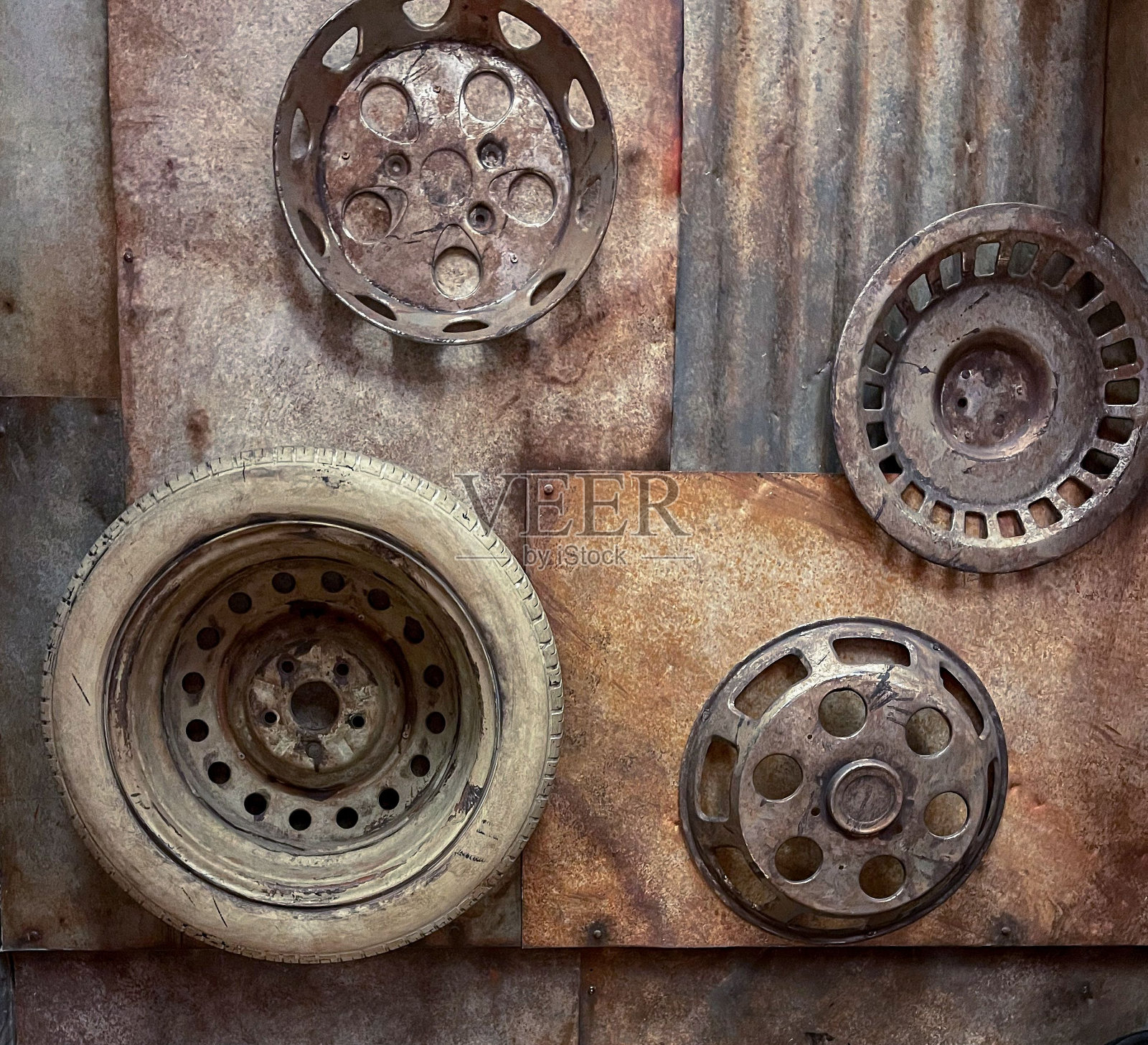 由旧汽车车轮和金属板制成的质朴的墙壁艺术创造了一种工业美学照片摄影图片