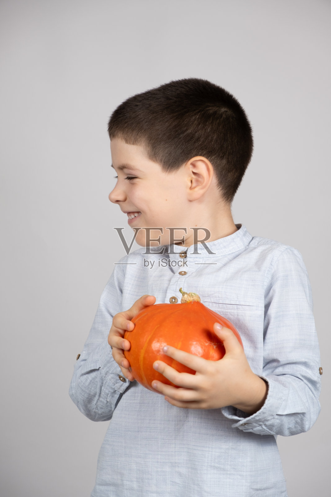 可爱快乐的孩子与小北海道南瓜在白色的背景。照片摄影图片