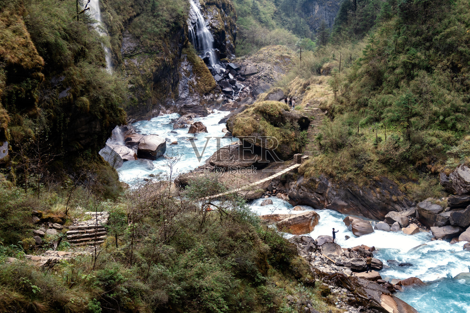 喜马拉雅山脉之间的瀑布，绿色的森林和充满岩石的河流。照片摄影图片