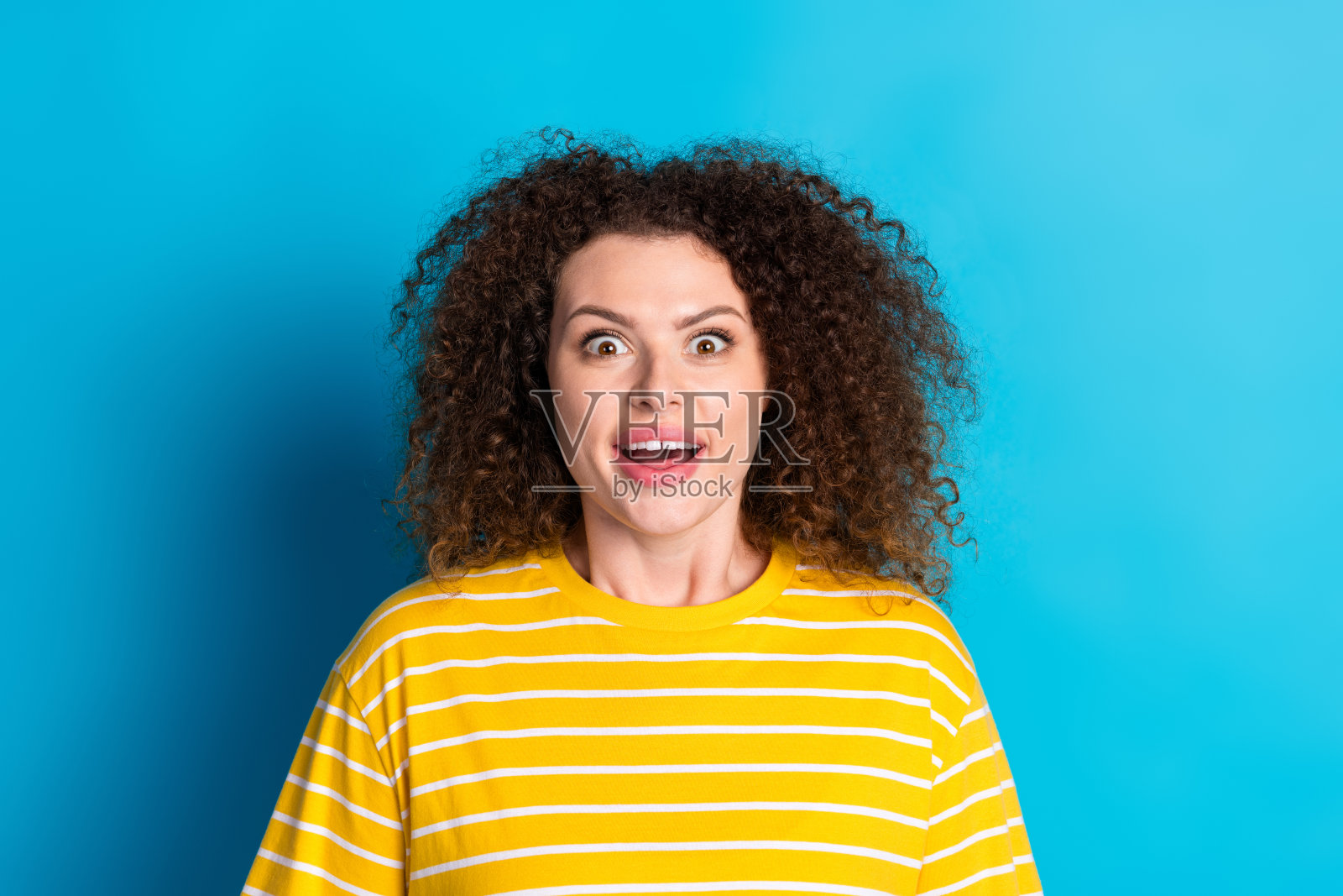 可爱的年轻女士的照片肖像惊讶兴奋的脸穿着时尚的条纹黄色服装孤立的蓝色背景照片摄影图片
