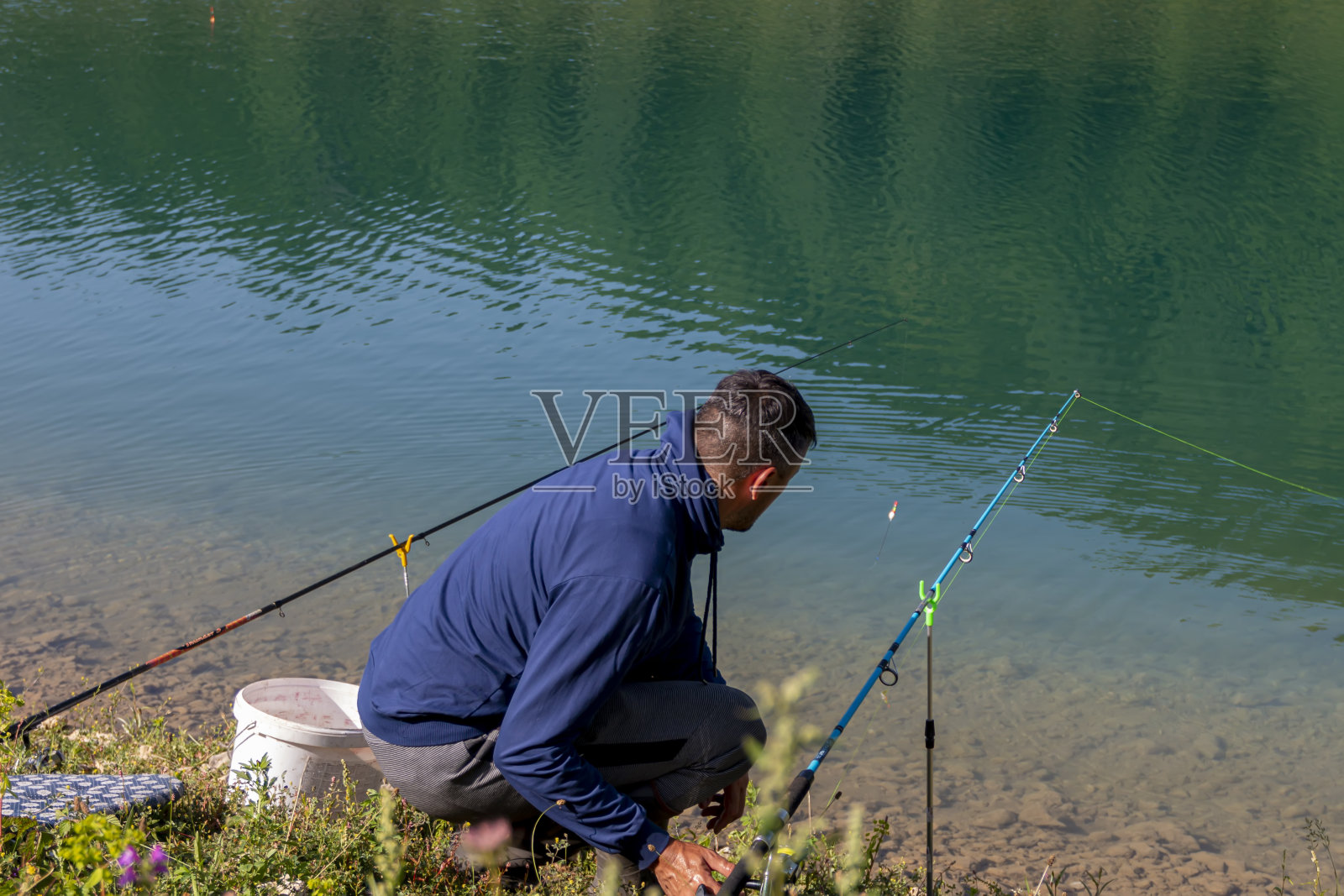 年轻人在湖上钓鱼照片摄影图片