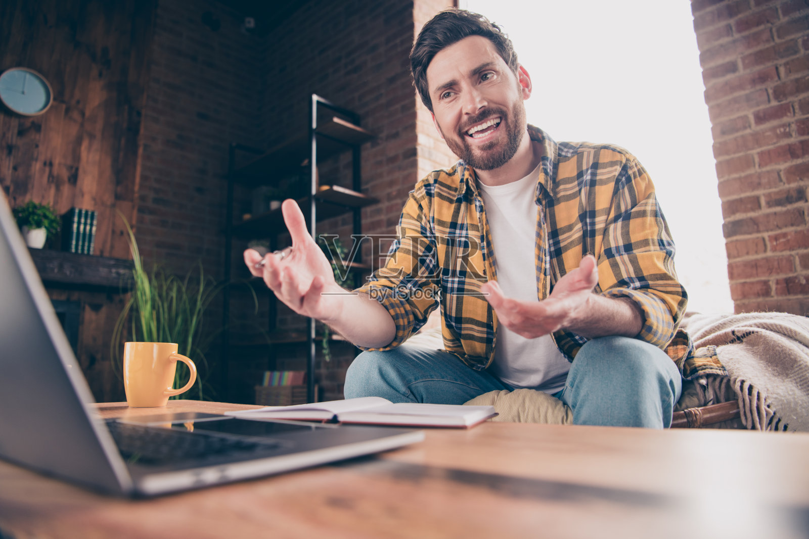 兴奋的酷哥穿着格子衬衫的照片视频会议现代设备在室内的房子公寓房间照片摄影图片