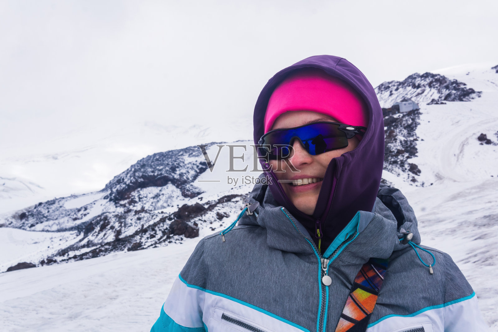 女登山运动员在厄尔布鲁士山雪坡上登顶的肖像。照片摄影图片