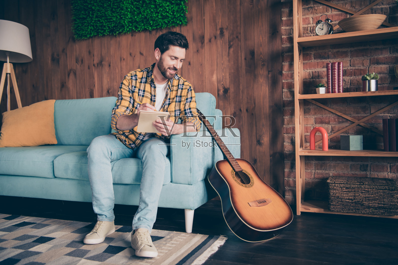 时髦酷的家伙穿着格子衬衫在房子里写歌的照片照片摄影图片