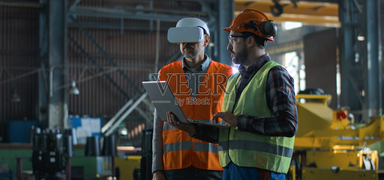 成熟的工程师使用VR头显，成年员工使用笔记本电脑工作照片摄影图片